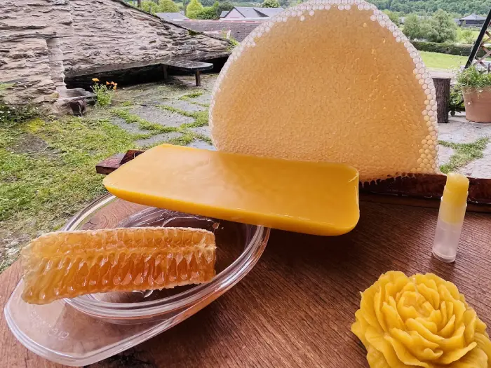un rayon de miel operculé en cire pure entouré de miel en rayon, d'un bloc de cire d'abeille pure, d'un baume et d'une bougie